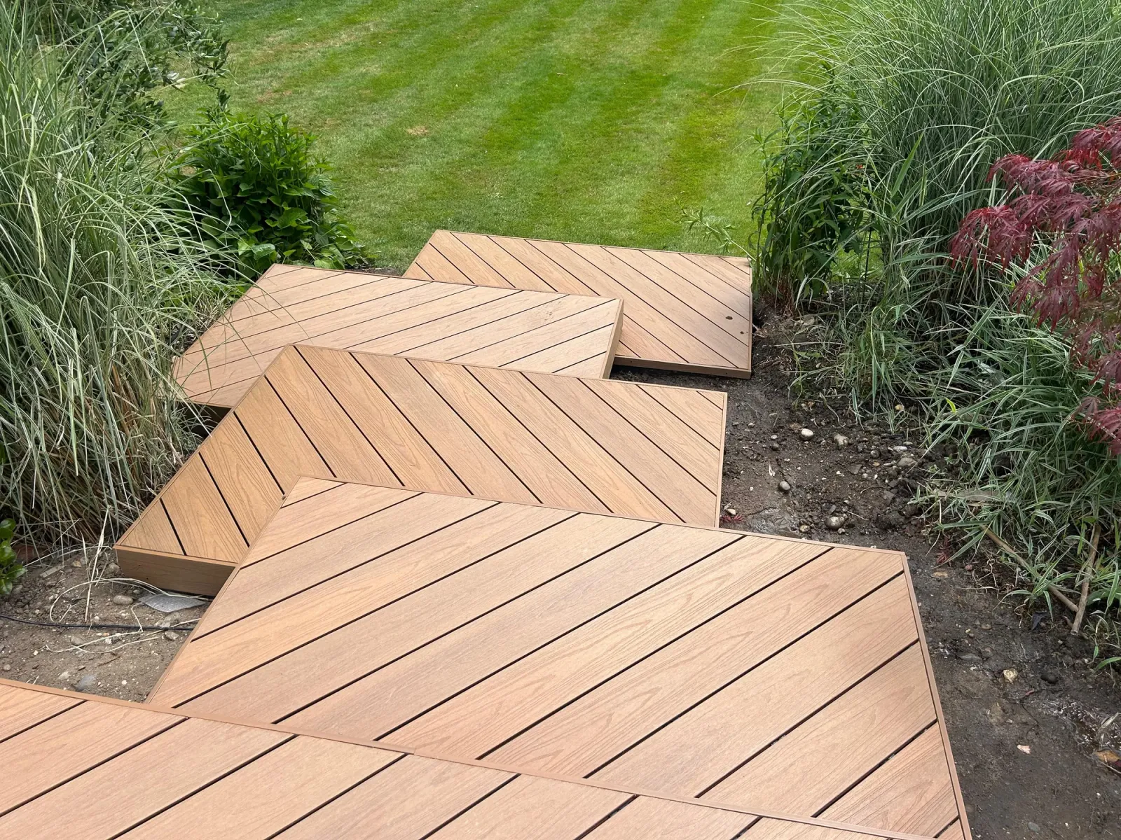 New composite decking with stepped levels and freshly planted borders