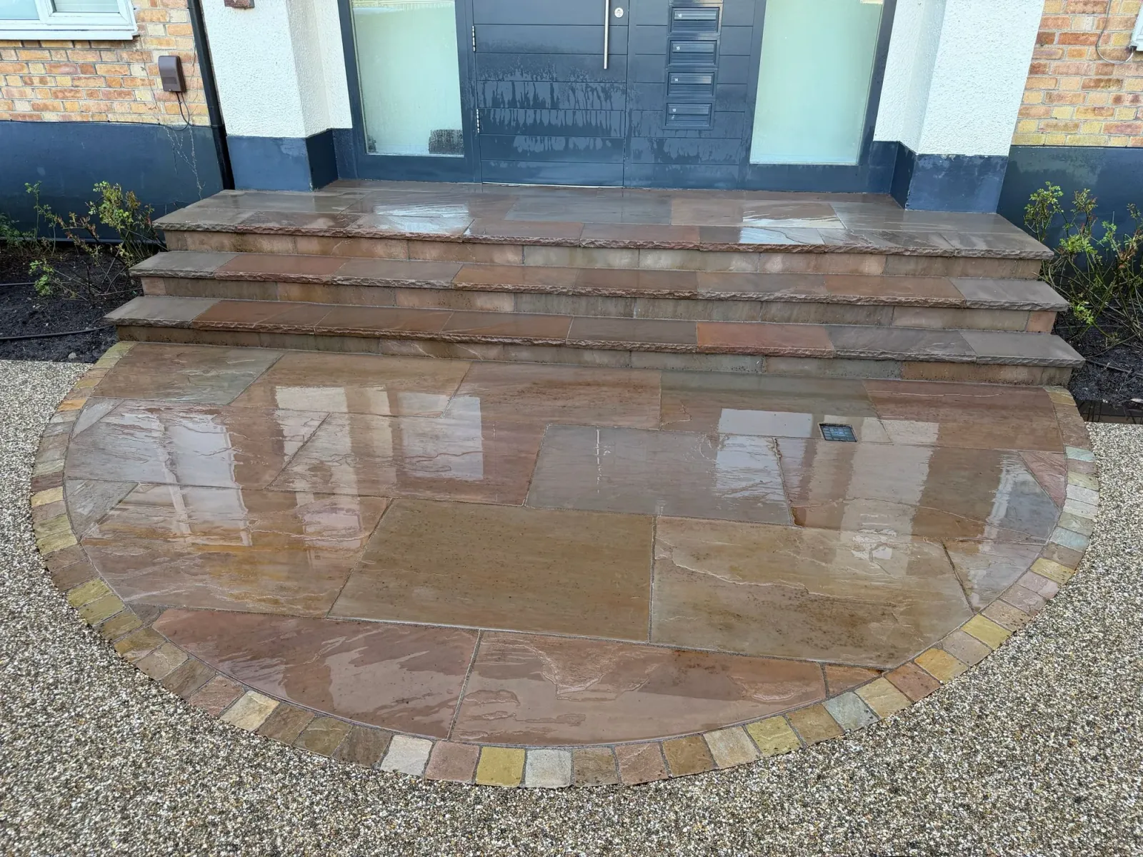 Indian sandstone front steps with brick-edge detail and red gravel surround