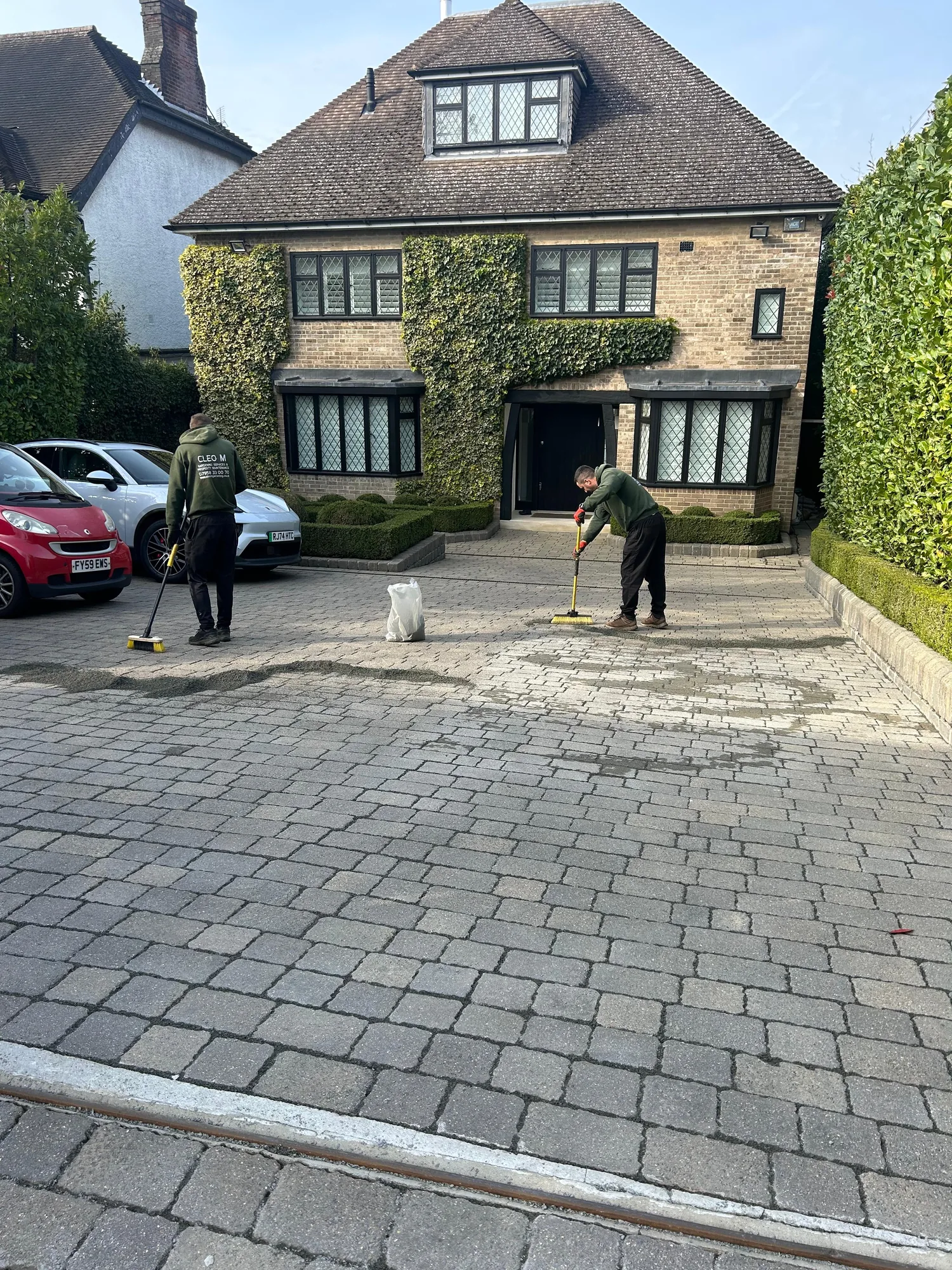 Mill Hill NW4 driveway, pressure-washed and joint-filling aggregate being swept in