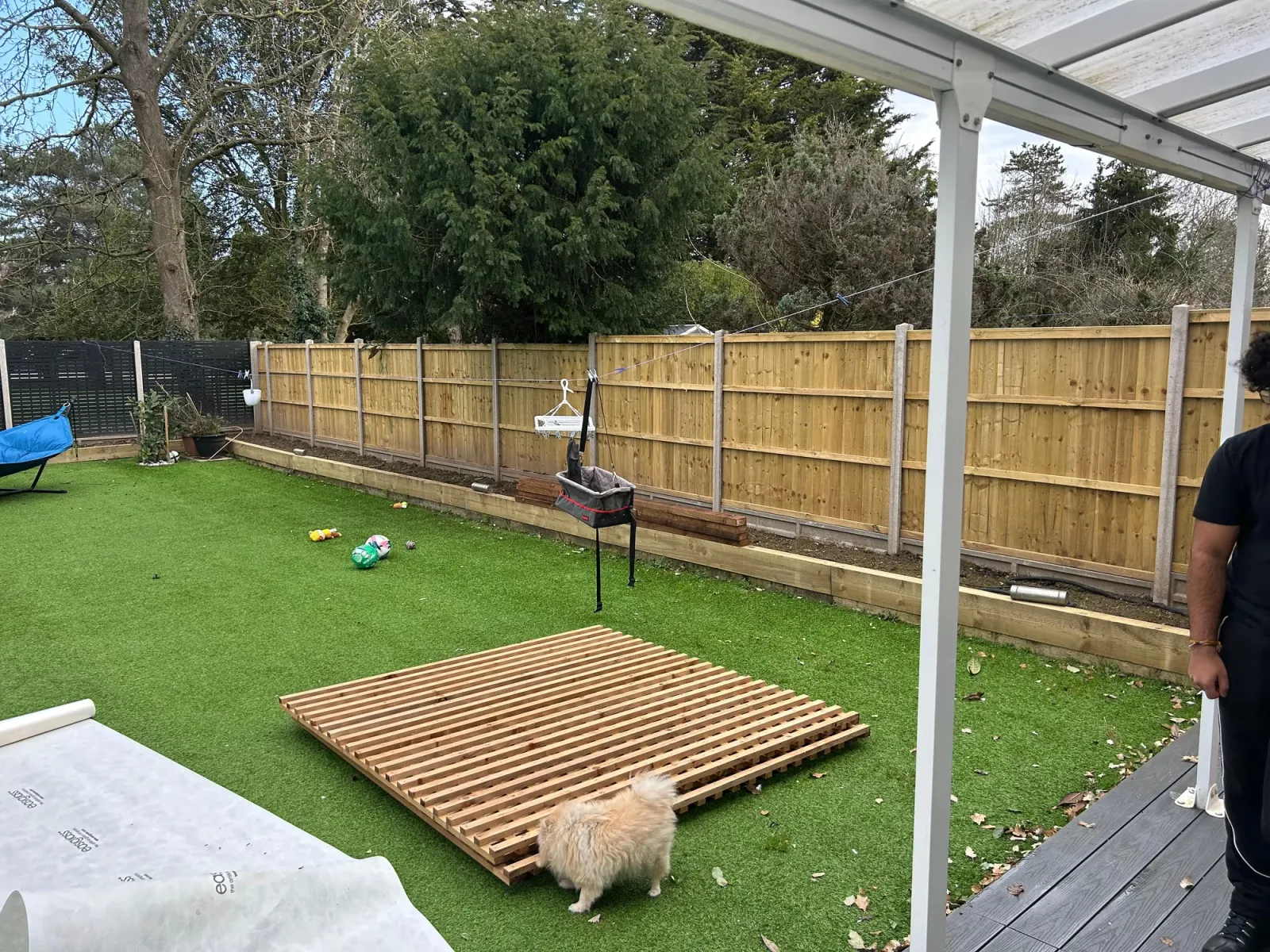 During: new wooden trellis panels laid out on the artificial grass ready for installation